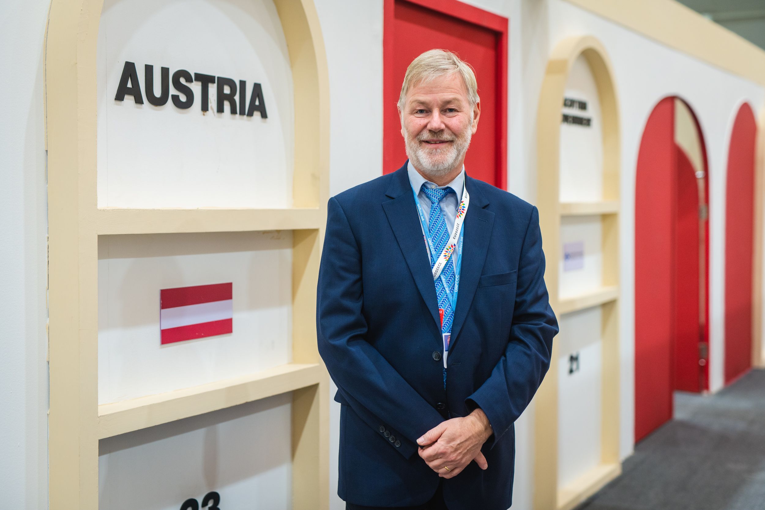 Delegationsleiter Helmut Hojesky steht vor einer Wand mit Österreich-Flagge bei der 27. Klimakonferenz
